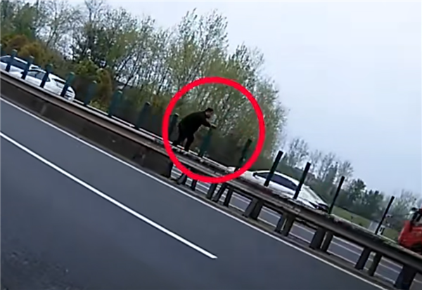 高速路快车道车辆追尾 男子肉身当警示牌：站护栏上来回摆手